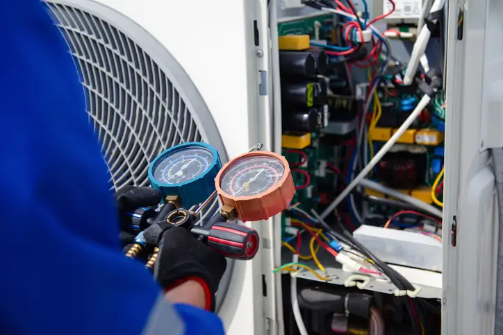 Triangle Environmental HVAC technician measuring commercial air conditioner unit in Illinois